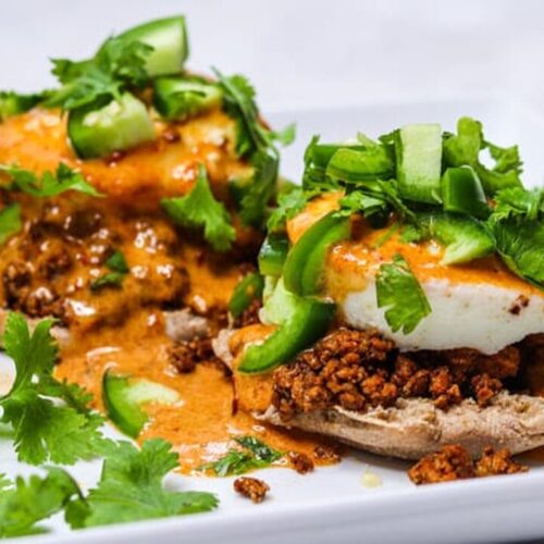 mexican eggs benedict with tofu chorizo chipotle hollaindaise served in a white plate
