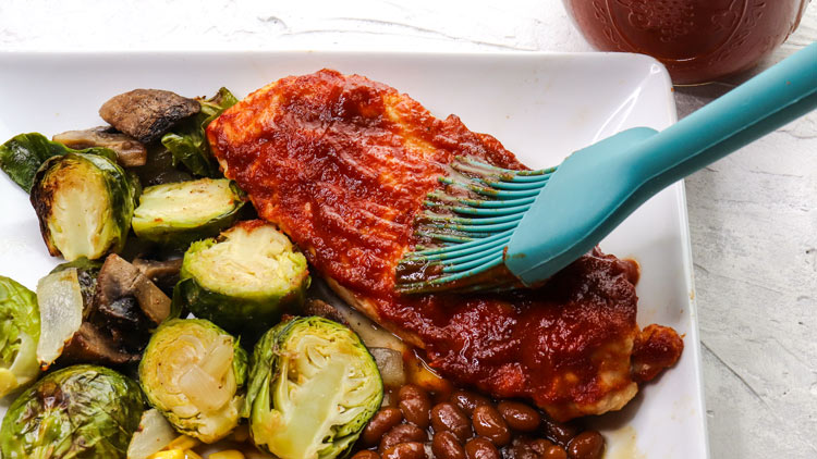 hickory smoked bbq sauce on top of a piece of meat, and some Brussel sprouts on the side
