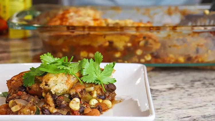 vegetarian fajita Mexican cornbread casserole served on a white plate and topped with fresh parsley