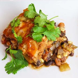 vegetarian fajita Mexican cornbread casserole served on a white plate and topped with fresh parsley